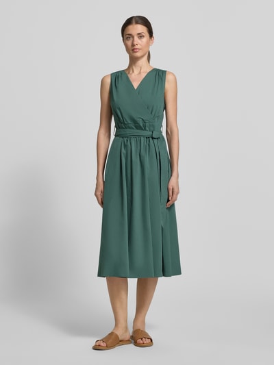 Frauenmodel trägt Midikleid mit V-Ausschnitt und Bindegürtel von ROBE LÉGÈRE in grünem Baumwoll-Mix, A-Linie, Ganzkörperansicht von vorne.