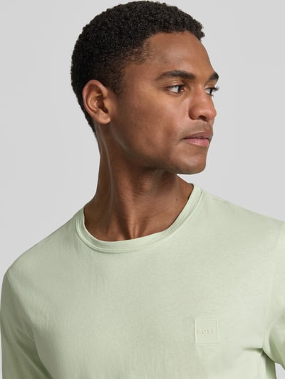 Męski model nosi Regular Fit T-Shirt aus reiner Baumwolle Modell 'TALES' von BOSS Orange, efekt: jednolity kolor, naszywka z logo, okrągły dekolt, krótki rękaw, bawełna, Nahaufnahme Oberkörper.