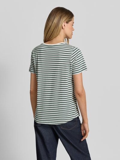 Frauenmodel trägt T-Shirt mit Motiv-Stitching und Rundhalsausschnitt von FREE/QUENT, weiße und grüne Streifen, Ganzkörperansicht Rückansicht.