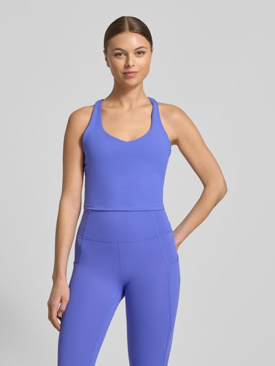 Frauenmodel trägt Slim Fit Top mit integriertem Bustier Modell 'Anywhere' von Fabletics in Blau, elastischer Mix, Nahaufnahme Oberkörper.