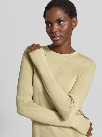 Frauenmodel trägt Slim Fit Longsleeve mit Logo-Print Modell 'Road' von ASICS TIGER in Hellgelb, glatte Textur, Rundhalsausschnitt, Nahaufnahme Oberkörper, Rückenlänge bei Größe S 61 cm.