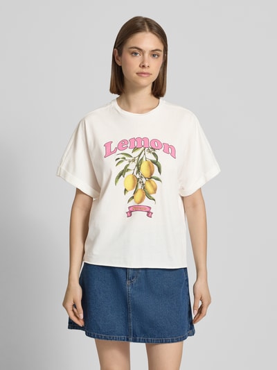 Frauenmodel trägt Boxy Fit T-Shirt aus reiner Baumwolle Modell 'MINNA' von Only, unifarben mit Motiv-Print, Ganzkörperansicht von vorne.