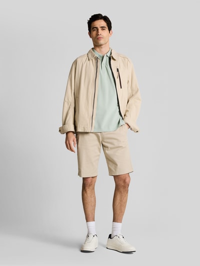 Männermodel trägt Regular Fit Poloshirt aus reiner Baumwolle von Tom Tailor, Optik: Unifarben, Piqué, Logo-Stitching, Ganzkörperansicht von vorne.
