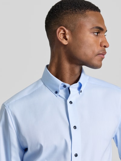 Männermodel trägt Regular Fit Business-Hemd mit Button-Down-Kragen von OLYMP aus reiner Baumwolle, Unifarbenes-Design, Nahaufnahme Oberkörper.