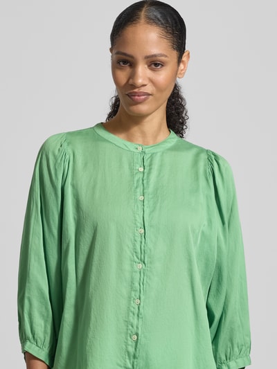Frauenmodel trägt Regular Fit Bluse mit Rundhalsausschnitt Modell 'FAVIOLA' von 0039 Italy aus reiner Baumwolle in Grün, 3/4-Arm, Nahaufnahme Oberkörper. Rückenlänge bei Größe S: 65 cm, Ärmellänge S: 47 cm, glatter Stoff, dezente Knopfleiste.