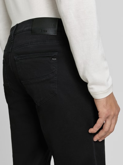 Männermodel trägt Regular Fit Weite Hose aus Baumwoll-Mix mit Lyocell-Anteil von Brax, schwarze Farbe, Detailaufnahme Rückansicht, Herren Weite Hose von Brax