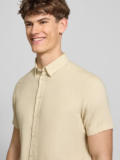 Männermodel trägt Slim Fit Leinenhemd mit Viskose-Anteil Modell 'Bobby' von Blend, beige, Kentkragen, Knopfleiste, Nahaufnahme Oberkörper. Kontext: Herren Leinenhemd, Leinen-Mix mit Viskose-Anteil, Kurzärmelig, Rückenlänge Größe M 75 cm, Schulterbreite 38 cm, Ärmellänge 23 cm.