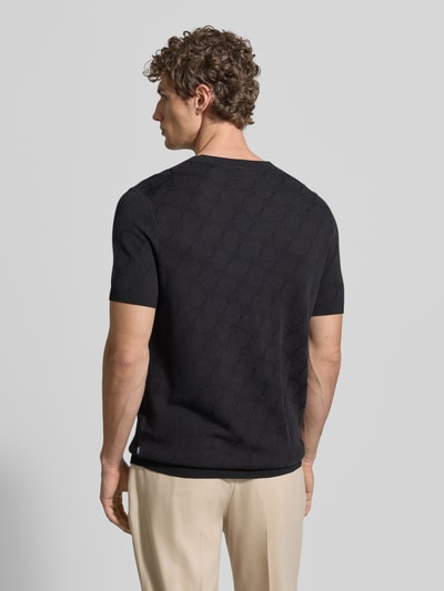 Männermodel trägt Herren T-Shirt mit Viskose-Anteil und Rundhalsausschnitt Modell 'Ravao' von JOOP! Collection, Modern Fit, Baumwoll-Mix, Label-Detail, Rückenlänge bei Größe M 69 cm, schwarze Farbe, feine Struktur, Ganzkörperansicht Rückansicht.