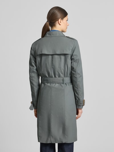 Frauenmodel trägt Regular Fit Mantel mit Umlegekragen Modell 'Lora' von Soyaconcept, Material-Mix mit Baumwoll-Anteil, taillierte Passform, Doppelreihige Knopfleiste, abnehmbarer Stoffgürtel, Eingrifftaschen, Farbe Grau, glatte Oberfläche, Ganzkörperansicht Rückansicht.