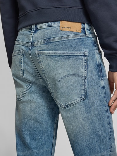 Männermodel trägt Slim Fit Jeans aus Baumwoll-Mix Modell 'Streem' von G-Star RAW in hellem Blau mit sichtbarer Struktur, Ganzkörperansicht Rückansicht.