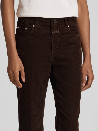 Frauenmodel trägt Straight Fit Jeans in Cord-Optik Modell 'Milo' von Closed in dunkelbraun, 5-Pocket-Design, Nahaufnahme Oberkörper.