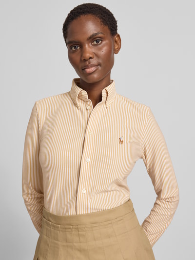 Frauenmodel trägt Regular Fit Hemdbluse aus reiner Baumwolle von Polo Ralph Lauren mit beigen und weißen Streifen, Nahaufnahme Oberkörper. Damen Hemdbluse von Polo Ralph Lauren.