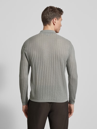 Männermodel trägt Slim Fit Pullover aus Lyocell-Mix mit Schurwoll-Anteil von Emporio Armani in Hellgrau mit Strick-Optik, Ganzkörperansicht Rückansicht.