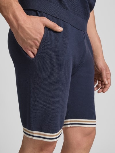 Männermodel trägt Shorts mit elastischem Bund und Eingrifftaschen von Christian Berg Men in Dunkelblau, reine Baumwolle, Nahaufnahme Oberschenkel.