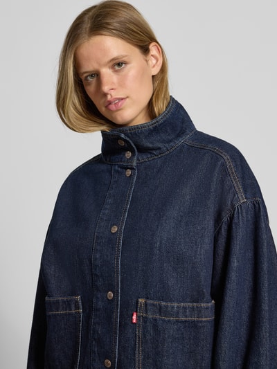 Frauenmodel trägt Modell 'T3 BLOUSON TRUCKER' von Levi's®, dunkelblaue Jeansjacke mit sichtbarer Struktur und Metallknöpfen, Nahaufnahme Oberkörper, Damen Jeansjacke von Levi's®.