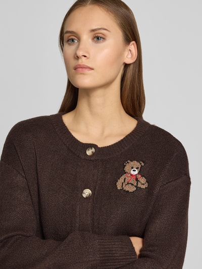 Frauenmodel trägt Relaxed Fit Strickpullover mit Stickerei Modell 'TEDDY' von ONLY in Dunkelbraun, feine Strickstruktur, Nahaufnahme Oberkörper, Damen Strickjacke von ONLY.