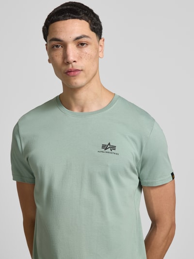 Männermodel trägt T-Shirt mit Label-Details Modell 'BASIC' von Alpha Industries in hellgrün, Reine Baumwolle, Gerader-Schnitt, Nahaufnahme Oberkörper.