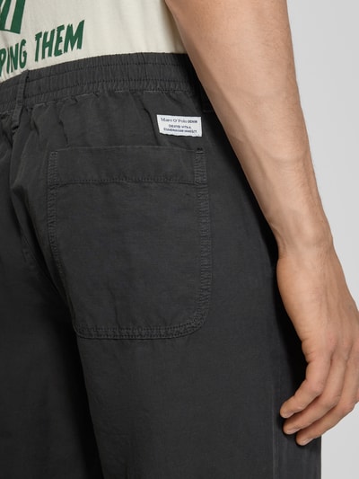 Männermodel trägt Relaxed Fit Chino aus Baumwolle-Leinen-Mix Modell 'FILIP RELAXED' von Marc O'Polo Denim, Optik: Unifarben, Passform: Relaxed-Fit, Applikation: Label-Patch, Details: Gürtelschlaufen, Verschluss: Knopf und Reißverschluss, Bundabschluss: elastisch, Material: Baumwolle-Leinen-Mix, Nahaufnahme Rückansicht.