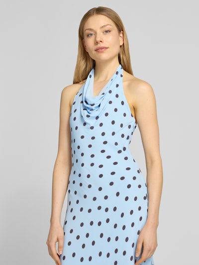 Frauenmodel trägt Cocktailkleid mit Wasserfall-Ausschnitt Modell 'Carter' von Forever New, figurbetont, Midikleid, hellblau mit schwarzen Punkten, glatte Textur, Nahaufnahme Oberkörper.