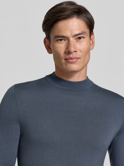 Männermodel trägt Slim Fit Longsleeve aus reiner Schurwolle Modell 'Arwon' von DRYKORN in Grau, angenehme Textur, Nahaufnahme Oberkörper.