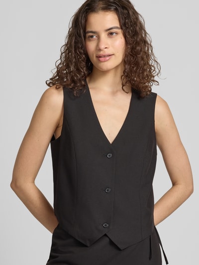 Frauenmodel trägt schwarze Regular Fit Anzugweste mit Viskose-Anteil Modell 'BOSELLA' von PIECES, glatte Textur, Nahaufnahme Oberkörper.
