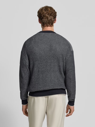 Männermodel trägt Regular Fit Strickpullover aus reiner Baumwolle von HECHTER PARIS in Dunkelgrau mit feiner Struktur, Ganzkörperansicht Rückansicht. Rückenlänge 63 cm, Ärmellänge 61 cm, elastische Abschlüsse, Rundhalsausschnitt.