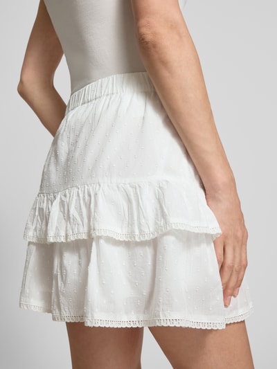 Frauenmodel trägt Volant Mini-Rock aus reiner Baumwolle 'TRINE' von Vero Moda, weiß, gepunktet, Popeline, Nahaufnahme Oberkörper Rückansicht.
