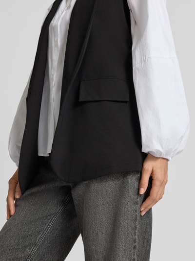 Vrouwenmodel draagt bodywarmer van Viscosemix met stretch, straight fit, Model 'Am44br' van ZABAIONE, met sjaalkraag en klepzak, detailopname heup