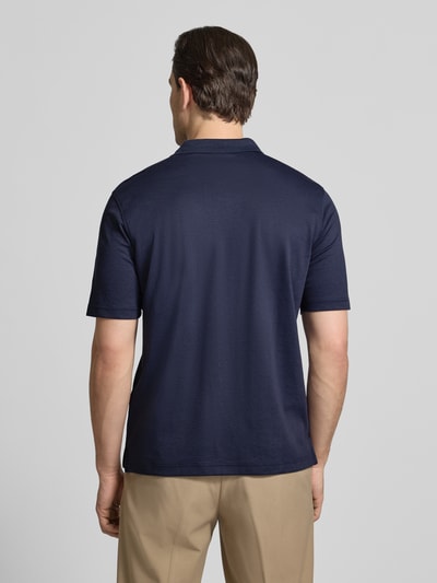 Mężczyzna nosi Regular Fit Poloshirt mit Brusttasche von Christian Berg Men w kolorze granatowym, krój regular fit, bawełniany materiał, widok całej sylwetki z tyłu.
