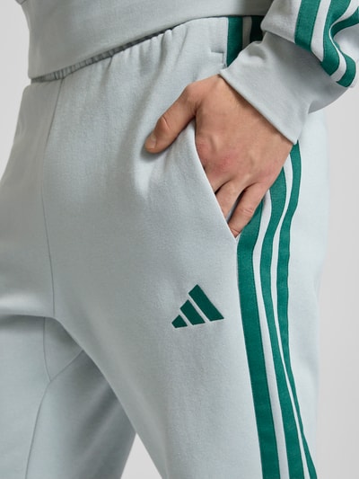 Männermodel draagt Sweathose mit Logo und elastischem Bund van adidas Sportswear, regular fit, puur katoen, detailopname heup.
