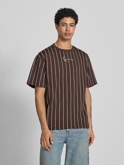 Männermodel trägt Regular Fit T-Shirt mit Logo-Stitching von KARL KANI aus Reine Baumwolle, braun mit weißen Streifen, Rundhalsausschnitt, Rückenlänge bei Größe M: 85 cm, Ganzkörperansicht von vorne.