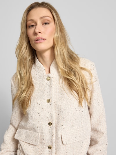 Frauenmodel trägt Regular Fit Kurzblazer mit Paillettenbesatz von s.Oliver BLACK LABEL in schimmernder Optik, Bouclé-Materialverarbeitung, Nahaufnahme Oberkörper.