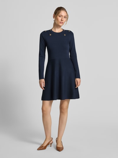 Frauenmodel trägt sukienka mini aus Mieszanka wiskozy Modell 'Abito Maglia' von Liu Jo White, dopasowany krój, ozdobne obszycie, navyblau, lekko rozkloszowany fason, długie rękawy, widoczne złote guziki, Długość tyłu w rozmiarze S: 85 cm, Szerokość w rozmiarze S: 40 cm, Długość rękawów w rozmiarze S: 35 cm, Ganzkörperansicht von vorne