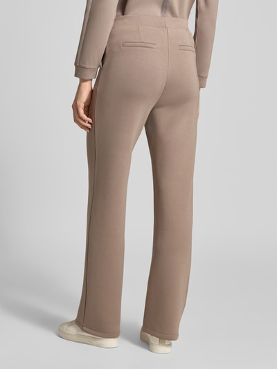 Frauenmodel trägt Stoffhose mit elastischem Bund von Betty Barclay, sandfarben, Viskose-Mix mit Stretch-Anteil, Gesäßtaschen, lockerer Schnitt, Ganzkörperansicht Rückansicht.