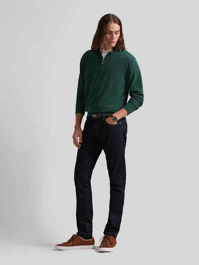 Männermodel trägt Regular Fit Sweatshirt aus Baumwoll-Mix von Polo Ralph Lauren in Dunkelgrün, kombiniert mit dunkler Jeans, Ganzkörperansicht von vorne. Herren Sweatshirt von Polo Ralph Lauren.
