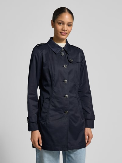 Frauenmodel trägt Trenchcoat mit Ärmelriegeln von Fuchs Schmitt in Dunkelblau mit Umlegekragen und Knopfleiste, Ganzkörperansicht von vorne.