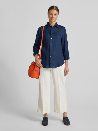 Kobiece model prezentuje Bluzka koszulowa z czystego lnu od Polo Ralph Lauren, granatowa, luźny krój, kołnierzyk koszulowy, listwa guzikowa, wyhaftowane logo, długość tyłu 70 cm, długość rękawów 58 cm, widok całej sylwetki z przodu.