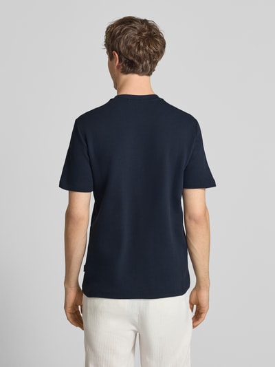 Męski model nosi T-Shirt mit Label-Detail Modell 'FILLIP' od Blend, granatowa bawełna, prosty krój, widok całej sylwetki z tyłu