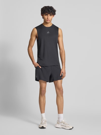 Männermodel trägt Regular Fit Sport-Shorts mit Logo-Print von adidas Training, Optik: Unifarben, Ganzkörperansicht von vorne.