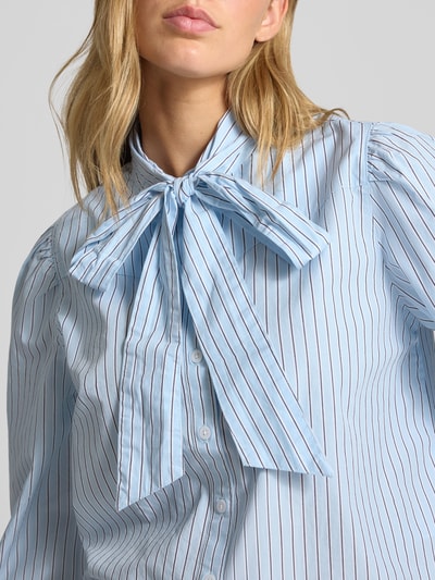 Frauenmodel trägt Regular Fit Langarmbluse aus reiner Baumwolle von Levi's® 300, hellblau mit feinen Streifen, Nahaufnahme Oberkörper.