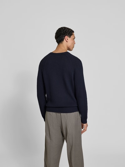 Männermodel trägt Regular Fit Pullover in Strick-Optik von Closed in Dunkelblau, Reine Baumwolle, Rundhalsausschnitt, Rückenlänge 64 cm, Ganzkörperansicht Rückansicht.