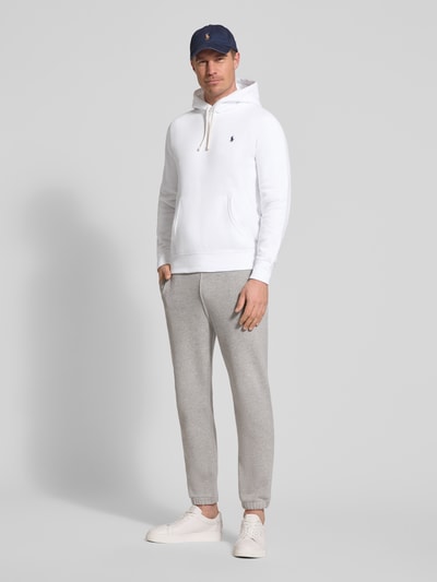 Männermodel trägt Regular Fit Hoodie aus Baumwoll-Mix von Polo Ralph Lauren in Optik: Unifarben mit Logo-Detail, Kängurutasche, Sweatstruktur, Ganzkörperansicht von vorne.
