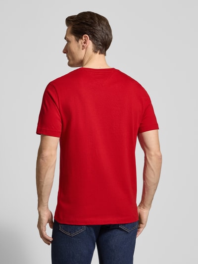 Männermodel trägt Regular Fit T-Shirt aus reiner Baumwolle von Tommy Hilfiger in Optik: Unifarben, rote Farbe, Jersey, Ganzkörperansicht Rückansicht.