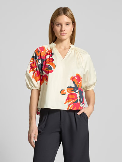 Frauenmodel trägt Regular Fit Bluse mit Tunikakragen und 1/2-Arm von HERZENS, cremefarben mit roten und schwarzen Blumenmustern, Baumwoll-Elasthan-Mix, Ganzkörperansicht von vorne.