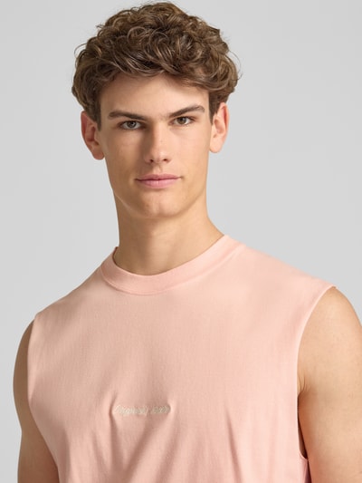 Männermodel trägt T-Shirt mit Stitching von Jack & Jones aus Reine Baumwolle in Rosa, Rundhalsausschnitt, Relaxed-Fit, Nahaufnahme Oberkörper.
