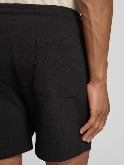 Männermodel trägt Regular Fit Shorts aus Baumwoll-Mix Modell 'FILIP' von Strellson, Optik: Unifarben, Materialverarbeitung: Jacquard, Nahaufnahme Rückansicht.