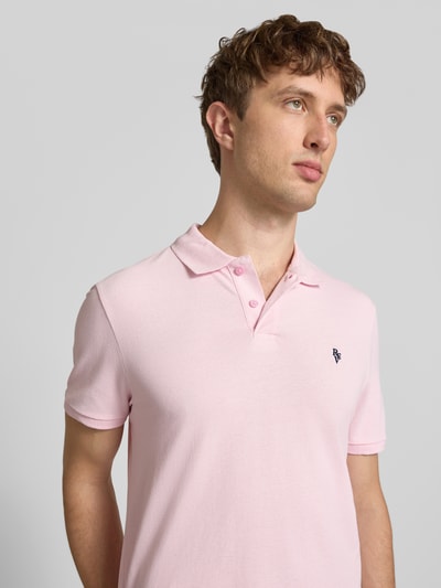 Männermodel trägt Modern Fit Poloshirt mit Logo-Stitching von REVIEW aus Baumwoll-Mix, hellrosa, kurze Knopfleiste, Nahaufnahme Oberkörper