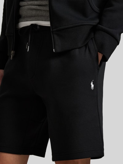 Männermodel trägt Regular Fit Sweatshorts aus Baumwoll-Mix von Polo Ralph Lauren in Schwarz mit Logo-Stitching, Nahaufnahme Oberschenkel.
