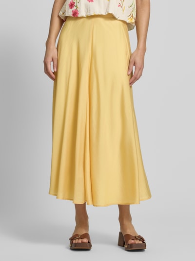 Vrouwenmodel draagt Midirock mit rückseitigem Reißverschluss van Jake*s Collection in gele satijn, a-lijn, volledige lichaamsvoorzijde.