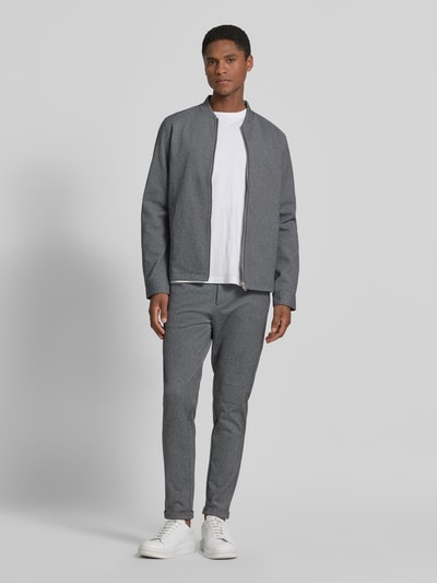 Męski model nosi Regular Fit Sweatjacke mit Stehkragen od Lindbergh, szara, z elastycznego materiału, zamek, kieszenie, krój regular fit, widok całej sylwetki z przodu.
